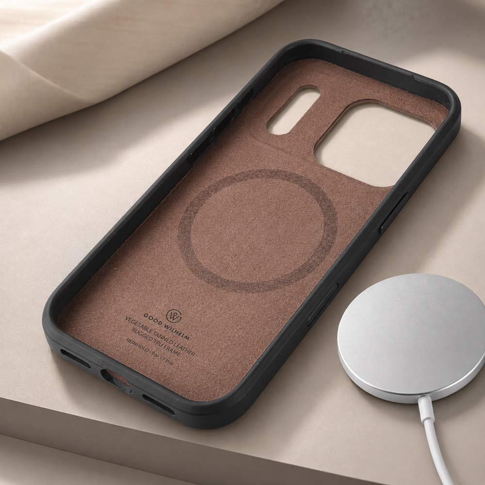 Auf einem Tisch liegt eine iPhone 17 Pro Max Hülle mit der Innenseite nach oben und daneben ein Magsafe Ladegerät