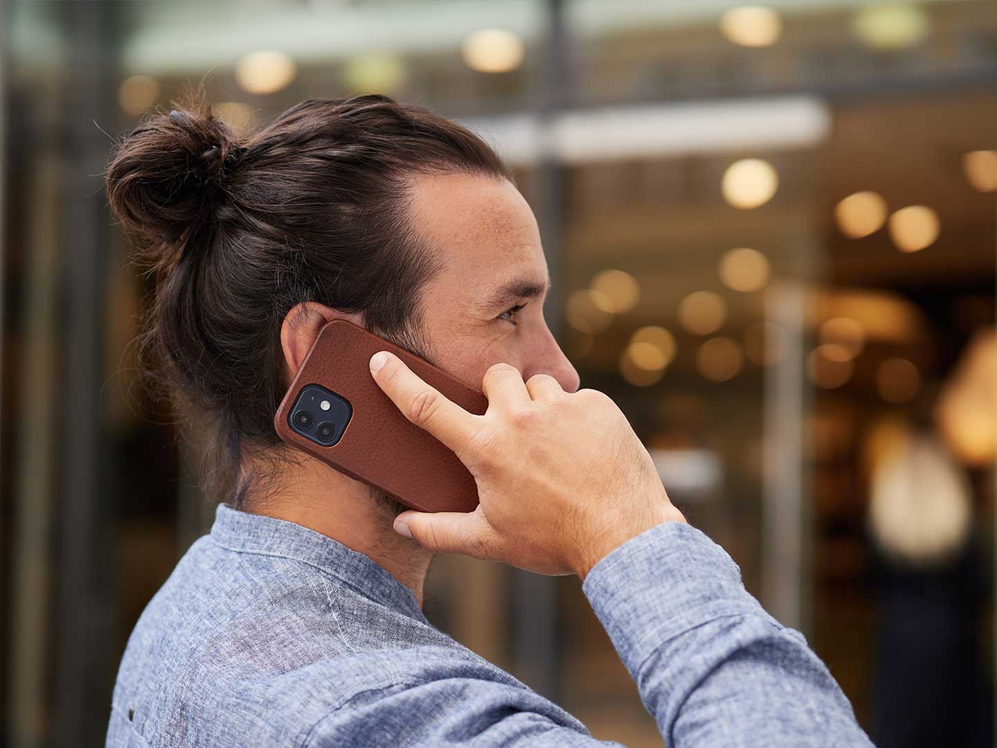 Ein Mann hält ein Telefon mit Schutzhülle an sein Ohr