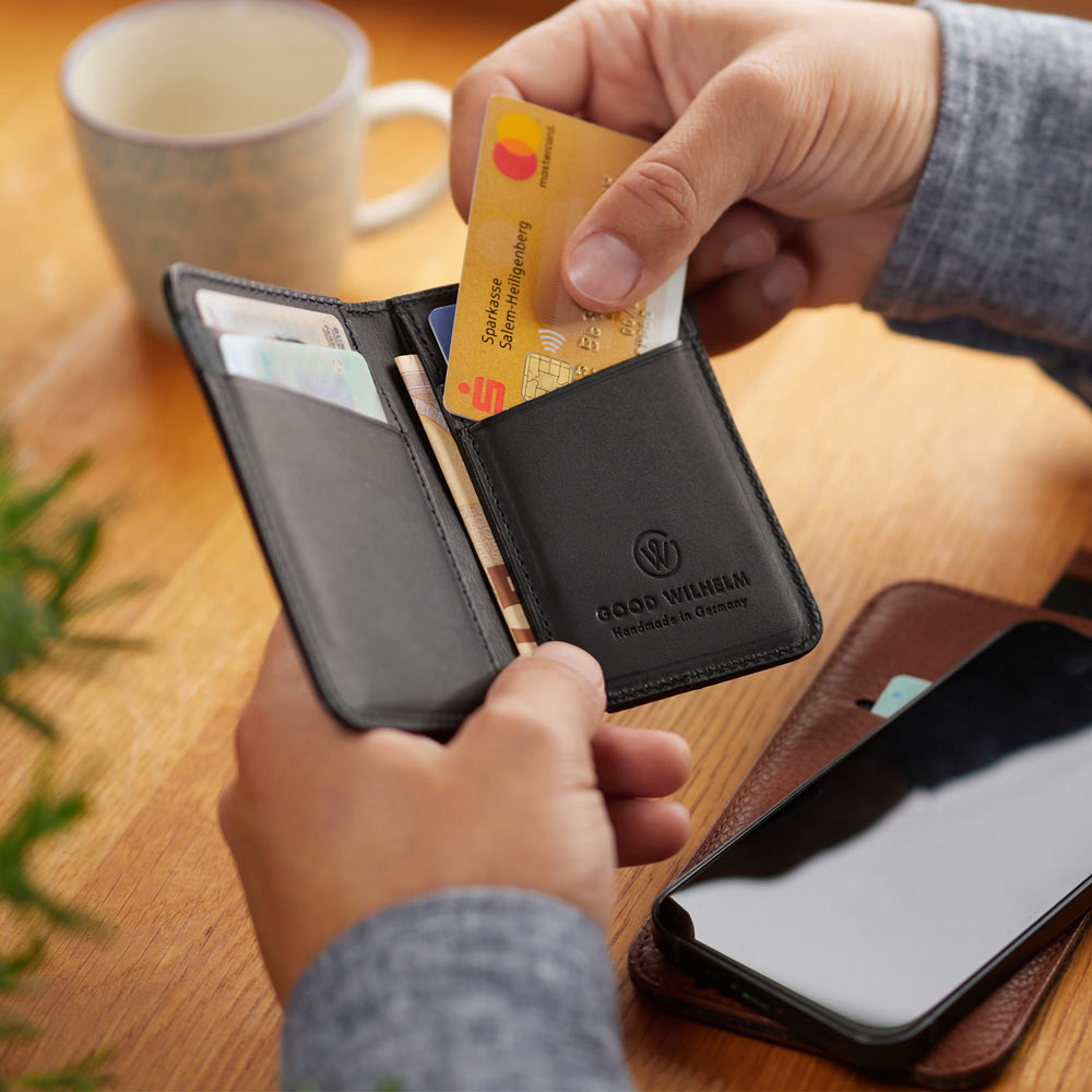 Offen gehaltene BiFold Wallet aus schwarzem Vacetta-Leder mit sichtbaren Kartenfächern und RFID-Schutz