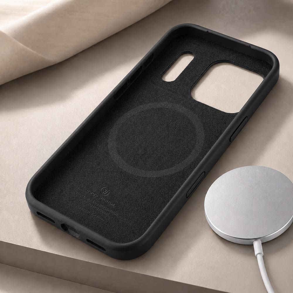 Auf einem Tisch liegt eine iPhone 17 Pro Max Hülle in Schwarz mit der Innenseite nach oben und daneben ein Magsafe Ladegerät