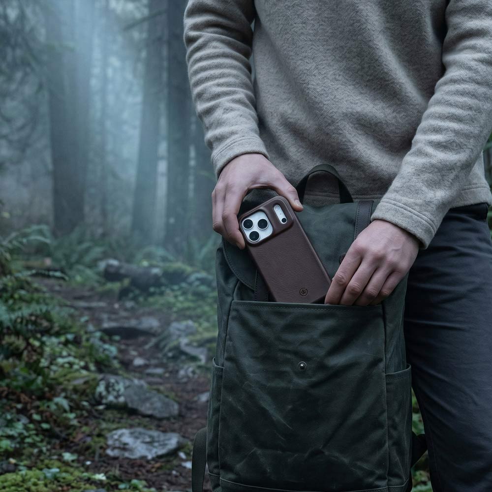 Ein Wanderer steckt eine iPhone 17 Pro Max Hülle aus Leder und TPU Rahmen in seinen Wanderrucksack