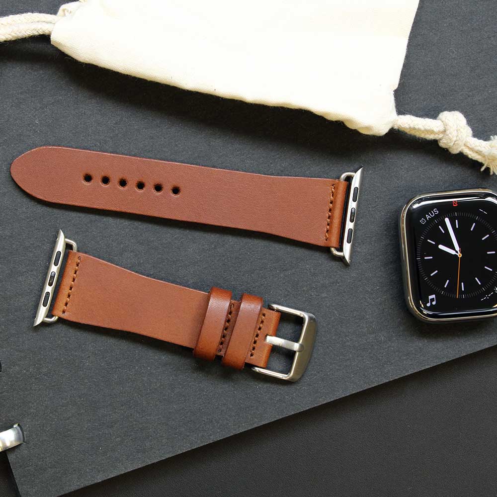 Auf einem Tisch liegen zwei Teile eines Lederarmbands für die Apple Watch aus Leder