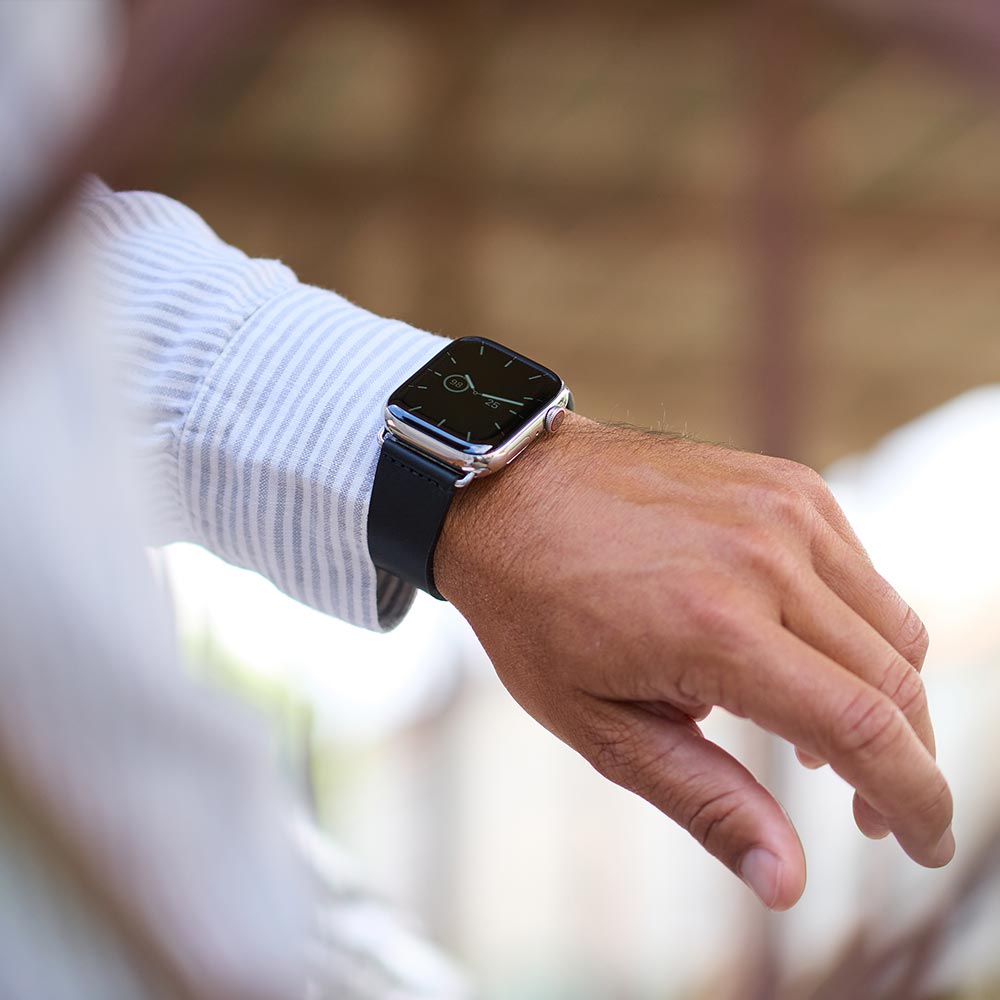 Ein Mann trägt an seinem Handgelenk eine Apple Uhr mit Lederarmband von Goodwilhelm in Schwarz